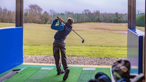 Young boy playing golf at Colin Glen driving range.