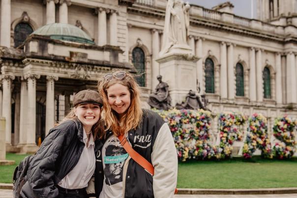 Two women smiling outside Belfast City Hall.
