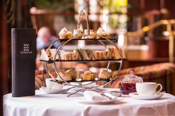 Image showcasing sandwiches, cupcakes, scones and tea as part of Europa Hotel's afternoon tea.