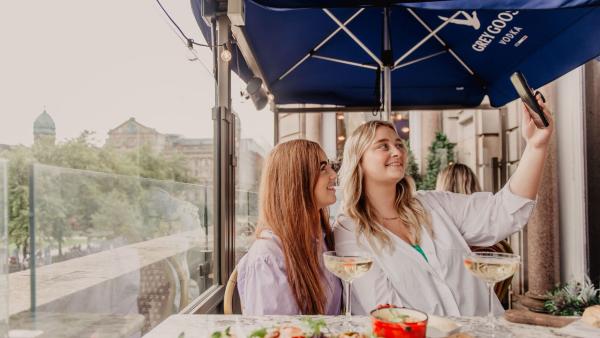 Two women taking a selfie on the terrace at Cafe Parisien