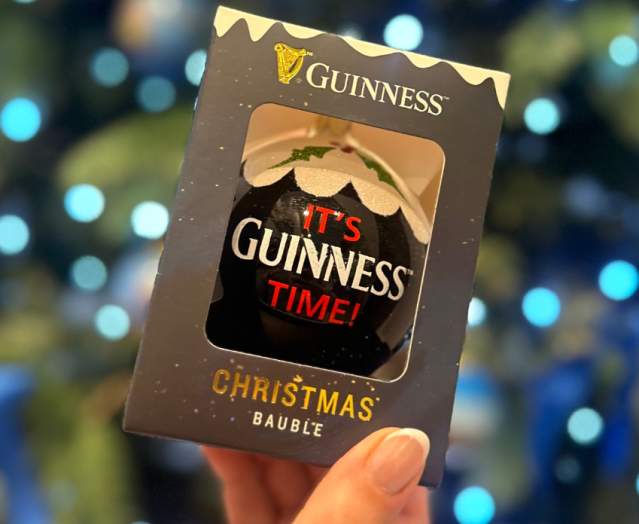 Photo of guinness branded bauble beside a christmas tree