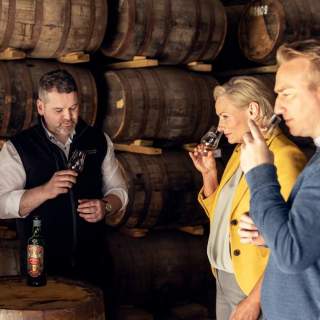 Group smelling whiskey with guide at distillery