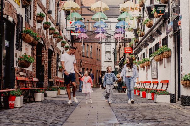 A family enjoying a walk through Belfast's famous Commercial Court.