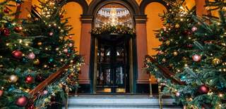 The entry to The Merchant Hotel decorated with Christmas Trees and lights