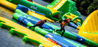 Two people running across inflatables on water