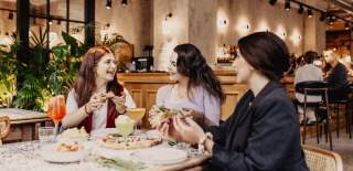 Group of girls enjoying pizza and drinks at Amelia Hall