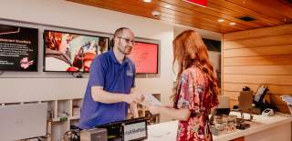 Man in Visit Belfast welcome centre helping tourists with information