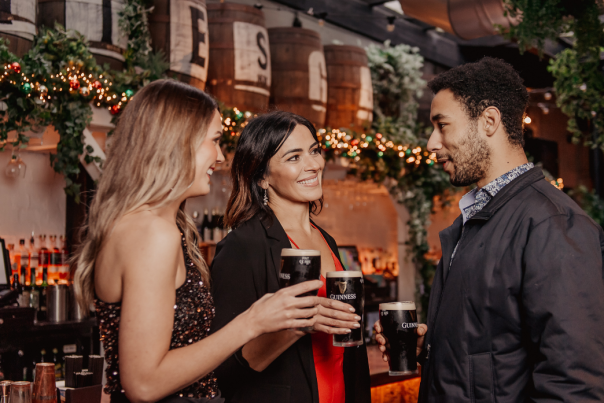 Friends at bar in Belfast with Guinness.